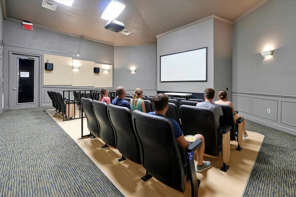 Two ordinary families settled into the existing theater seats watching a movie with bowls of popcorn, parents and kids in plain clothes, faces softly