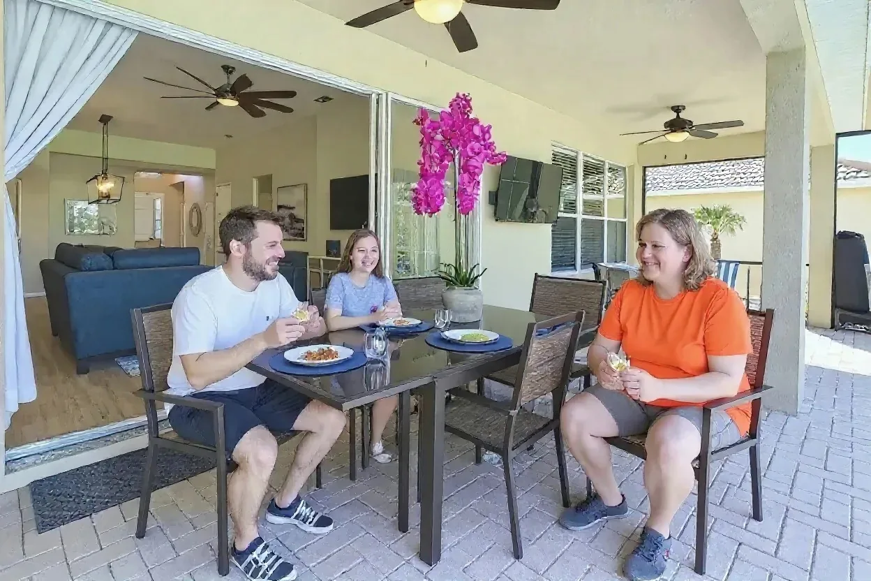A family sharing an easy taco dinner at the covered patio table of a Windsor Hills vacation home