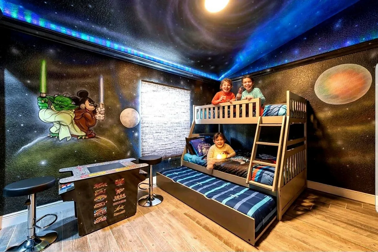 Two kids in pajamas on the existing bunk bed holding small flashlights and grinning