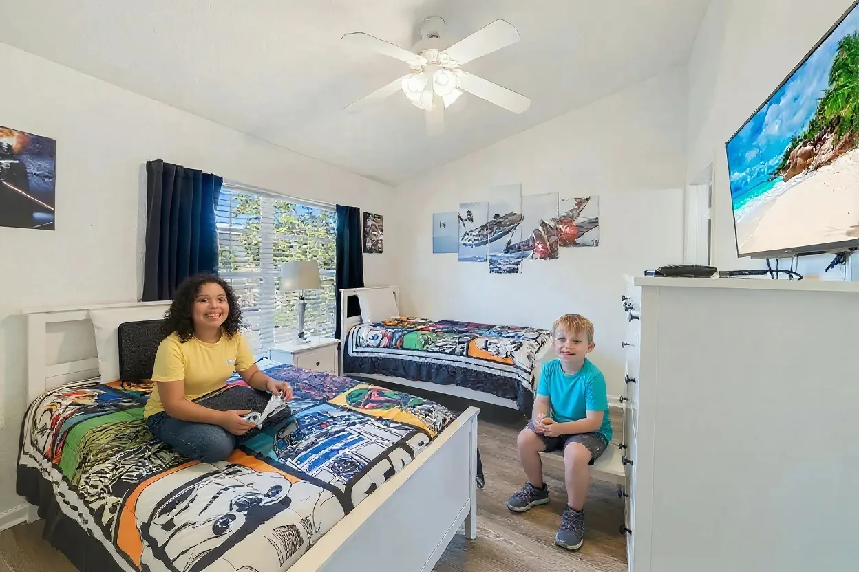 Two kids unpacking a suitcase in a themed kids bedroom with twin beds