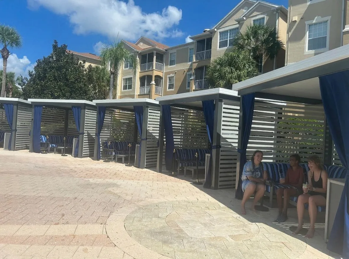 A family relaxing with cold drinks in a poolside cabana at Windsor Hills Resort