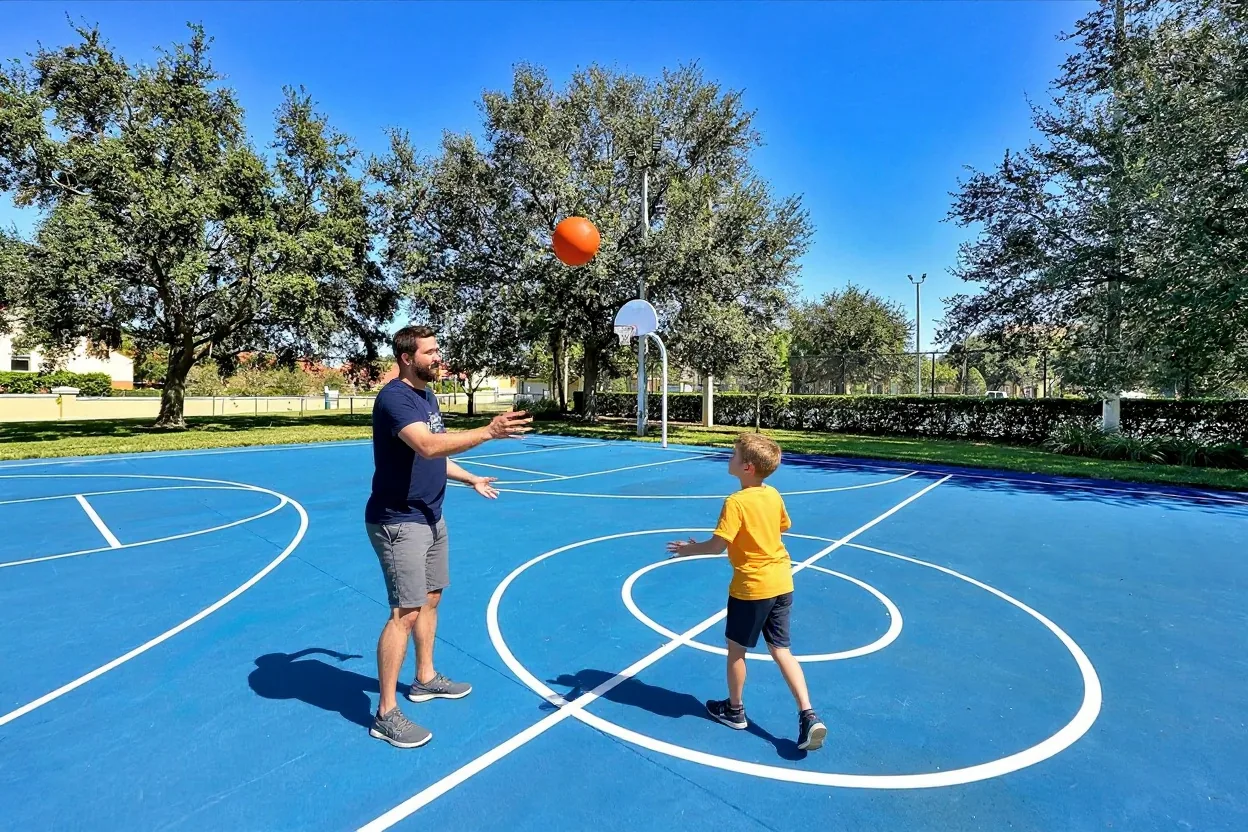 A dad and his son playing basketball on the blue court at Windsor Hills