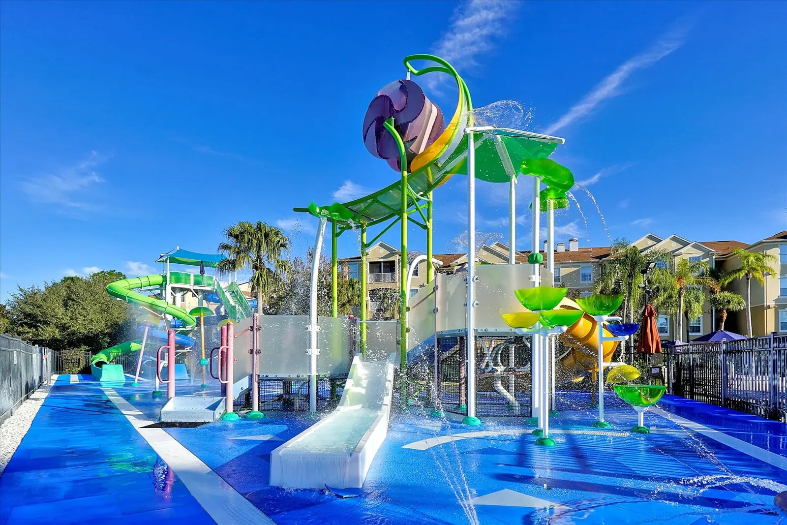 The colorful splash pad and water play structure at Windsor Hills Resort under a bright blue sky